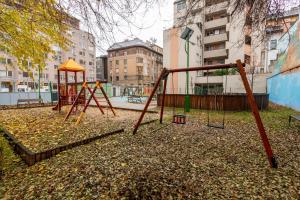 an empty playground with a swing set in a city at Central and New apartment with AC in Budapest