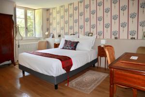 a bedroom with a bed and a desk and a piano at La Feuillaie in Saint-Ay