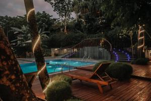 a pool with a wooden deck with a bench and a chair at De Foret in Havelock Island