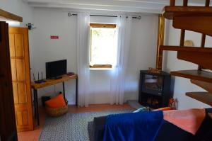 uma sala de estar com lareira e uma janela em Casa do Pássaro em Galegos