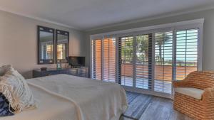 Un dormitorio con una cama y una silla y ventanas. en Aegean 210 - Updated 2 Bedroom 2 Bath at the Aegean, en Destin 13 fotos más