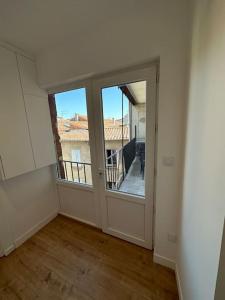 Habitación vacía con puerta grande y balcón en T3 Capitole-Climatisation-Balcon en Toulouse