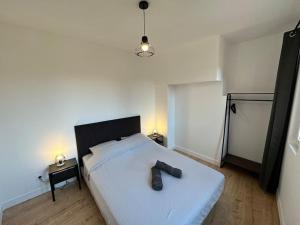 Un dormitorio con una cama con un par de zapatos. en T3 Capitole-Climatisation-Balcon en Toulouse