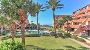 Un complejo con palmeras y piscina. en Aegean 210 - Updated 2 Bedroom 2 Bath at the Aegean, en Destin