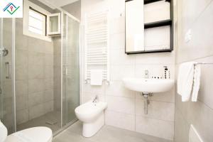a white bathroom with a sink and a toilet at LeS House - Apartment 1 in Pisa