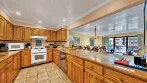 a large kitchen with wooden cabinets and white appliances at Aegean 215 - Beautiful Beachfront Condo Lots of on site Activities in Destin