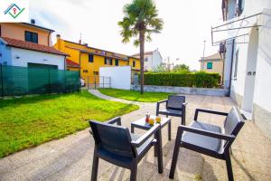 eine Terrasse mit 3 Stühlen und einem Tisch mit Getränken darauf in der Unterkunft LeS House - Apartment 1 in Pisa