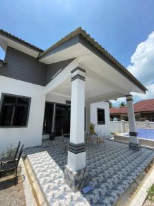 a white house with a pavilion on a patio at Homestay PCB Villa MamaKaya in Kota Bharu +12 photos