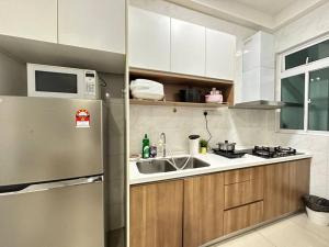 eine Küche mit einem Kühlschrank aus Edelstahl und einer Spüle in der Unterkunft Twin Galaxy 2 Bedroom Netflix 5-7 Pax Stylish Suite in Johor Bahru