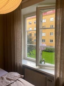 Un dormitorio con una ventana con un jarrón de flores en Shared apartment close to the city center en Estocolmo