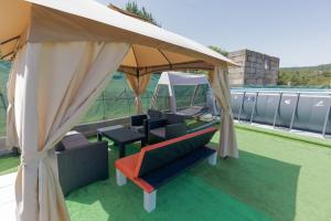 a gazebo with a table and chairs under it at Casa Luna Rural Con Piscina y Jardín in Ourense