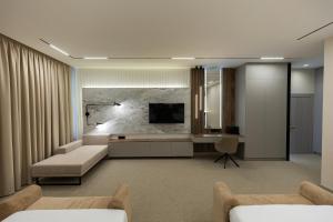 a living room with two beds and a television at The Amsterdam Boutique Hotel in Aktobe