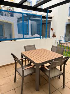 Une table et des chaises en bois sont disponibles sur la terrasse. dans l'établissement Real Village Praia Verde 142, à Praia Verde