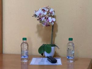 un jarrón con una flor y dos botellas de agua en Hotel-Villas JABEL TINAMIT, en Panajachel
