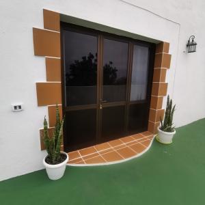 um edifício com dois vasos de plantas numa varanda em La Montaña 2 em Sabinosa