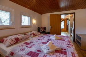 a bedroom with a large bed with towels on it at Apartmaji Preželj in Bohinj