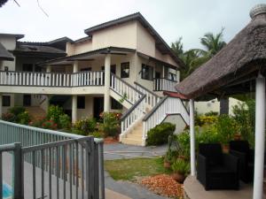 a large house with a staircase leading to it at Appartement d'une chambre a Grand Popo a 10 m de la plage avec piscine partagee jardin clos et wifi in Grand-Popo