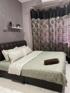 Schlafzimmer mit einem Bett mit einem schwarzen Kopfteil in der Unterkunft Homestay Permai Inn in Temerloh