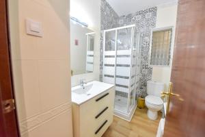 a bathroom with a white sink and a toilet at New! Spacious & River in Seville
