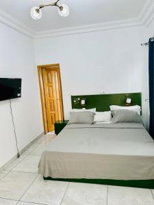 a bedroom with a large bed and a television at Johen Residence in Douala