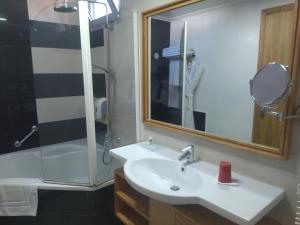 a bathroom with a sink and a shower and a mirror at Le Pietri Urban Hotel in Rabat