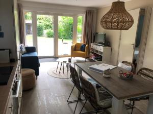 a living room with a dining room table and a living room at 't Achterom in Bruinisse