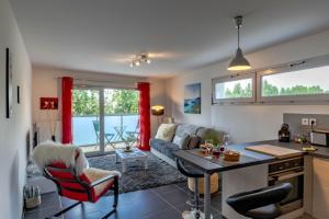Una cocina y una sala de estar con un sofá y una mesa. en Le Coquelicot 3 étoiles - Proche vieille ville, calme & confort, en Annecy