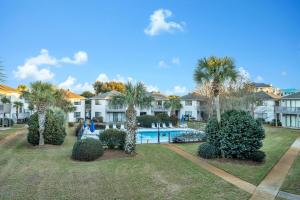 a villa with a swimming pool and palm trees at Crystal Village II 6B - Close to the Beach 2BD 2BA in Destin