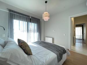 a bedroom with a large bed with a large window at Urban Oasis in Ellinikon in Athens