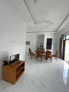 a living room with a tv and a table and chairs at Homestay PCB Villa MamaKaya in Kota Bharu