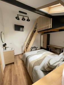 a bedroom with a large bed and a staircase at Au Bord de L'Eau in Écluzelles