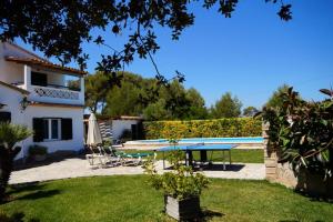 vistas al patio trasero de una casa con mesa y piscina en Villa Volentina, en Puerto Pollensa