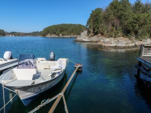 a boat is docked at a dock on a lake at Holiday Home Sjøhytta - FJH675 by Interhome in Bekkjarvik