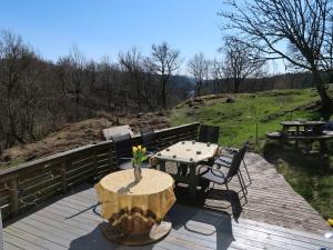 a wooden deck with a table and chairs on it at Holiday Home Sjøhytta - FJH675 by Interhome in Bekkjarvik