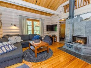 ein Wohnzimmer mit Couch und Kamin in der Unterkunft Holiday Home Pyöröpirtti by Interhome in Hattusaari