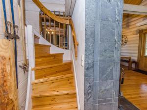 eine Treppe in einer Holzhütte mit einer Duschtür aus Glas in der Unterkunft Holiday Home Pyöröpirtti by Interhome in Hattusaari