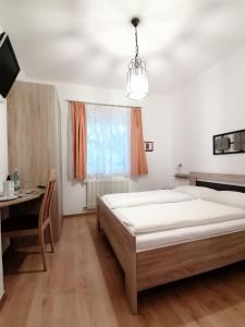 sypialnia z łóżkiem, biurkiem i oknem w obiekcie Pension Sunnhofer w mieście Vilpiano
