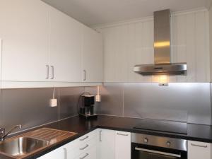 eine Küche mit weißen Schränken und einem Waschbecken in der Unterkunft Holiday Home Sognesjön - FJS128 by Interhome in Bø