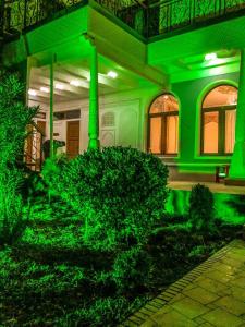 a house with green lighting on the front of it at Tasvir Hotel in Bukhara