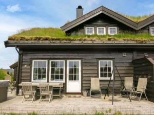 una casa con una mesa y sillas frente a ella en Holiday Home Fjellheimen - SOW138 by Interhome en Åseral