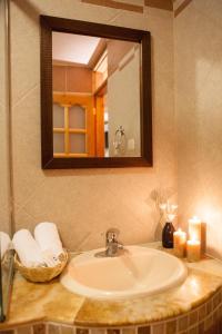 La salle de bains est pourvue d'un lavabo, d'un miroir et de bougies. dans l'établissement Maimara Hotel, à Huaraz