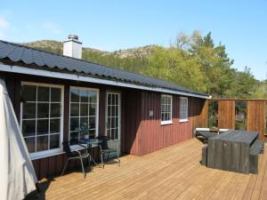 a house with a deck with a table and chairs at Holiday Home Utsikt - SOW148 by Interhome in Fossdal