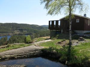 a house on a hill next to a river at Holiday Home Utsikt - SOW148 by Interhome in Fossdal