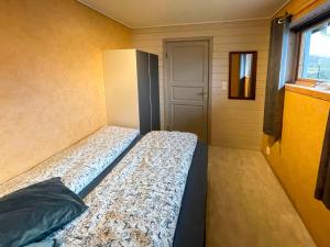 uma cama num pequeno quarto com uma janela em Apartment Bakkafall - FJS078 by Interhome em Svortevik