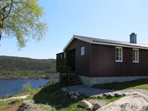 a house on a hill next to a body of water at Holiday Home Utsikt - SOW148 by Interhome in Fossdal