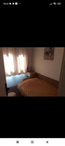 - une chambre avec un lit et une fenêtre avec des rideaux dans l'établissement Smeštaj Stanojević, à Pribojska Banja