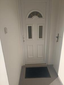 a white door with a black door mat in a hallway at Smeštaj Stanojević in Pribojska Banja