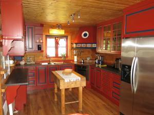 cocina con armarios rojos y suelo de madera en Chalet Lindefjeldbu - SOW144 by Interhome en Fossdal