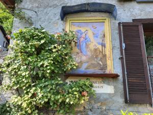 ein Gemälde auf der Seite eines Gebäudes mit Pflanzen in der Unterkunft Holiday Home Bellavista by Interhome in Ronco sopra Ascona