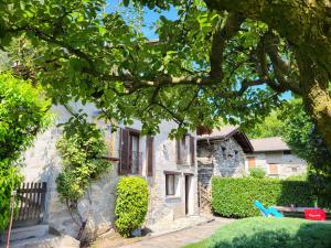 ein Steinhaus mit einem Baum davor in der Unterkunft Holiday Home Bellavista by Interhome in Ronco sopra Ascona